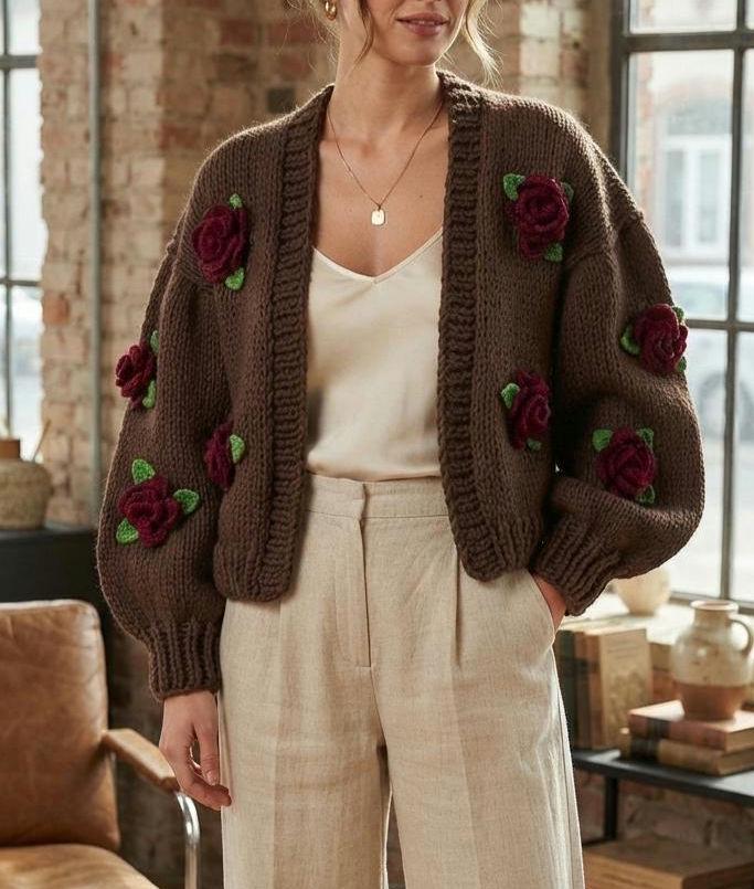 Chocolate brown hand-knit cardigan with crocheted red roses, worn over a cream top